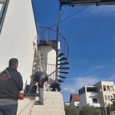 Podizanje spiralnog čeličnog stubišta uz bijelu kuću