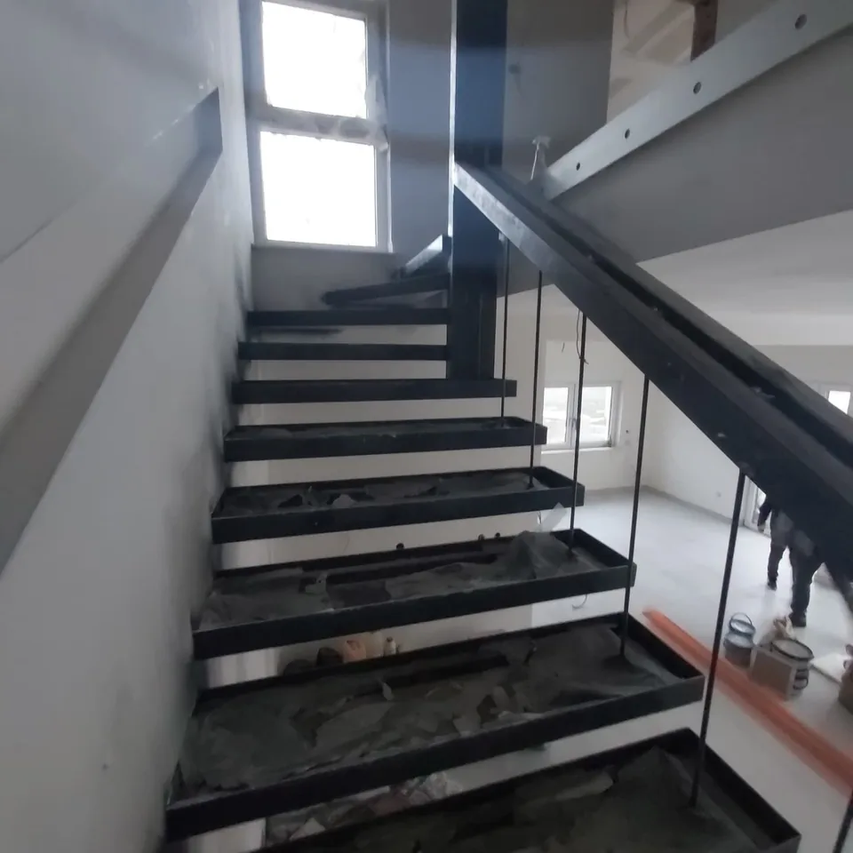 Crni čelični okviri gazišta stubišta uz visoki prozor