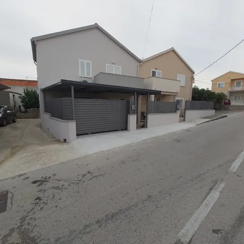 Dvojna kuća s antracitnom nadstrešnicom i lamelnom ogradom