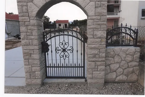 Kovana pješačka vrata u kamenom lučnom ulazu