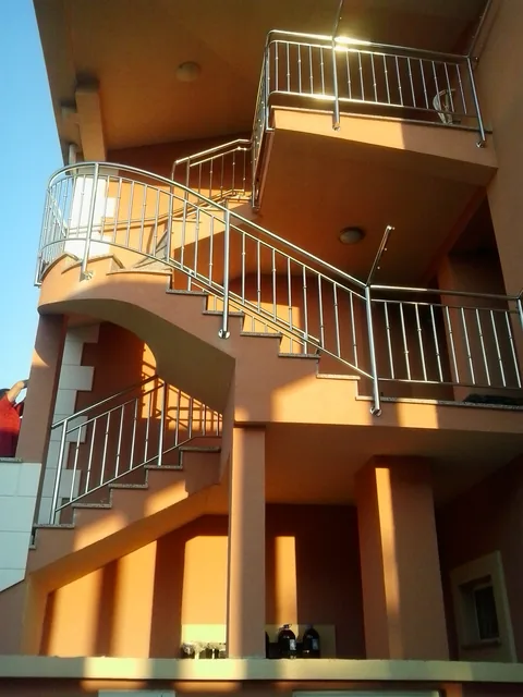 Unutarnja inox ograda oko stubišta u toplom interijeru