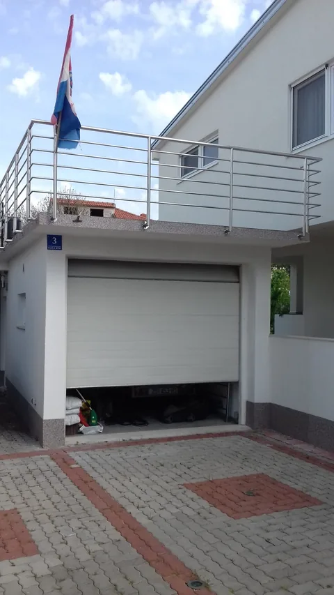 Pročelje s garažom i vanjskim balkonom s inox ogradom