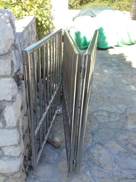 Složena preklopna inox dvorišna vrata uz kameni stup