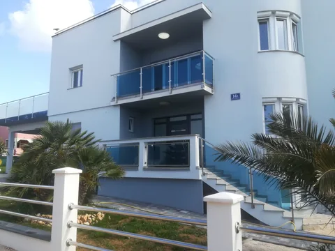 Kuća sa staklenim balkonima, vanjskim stubama i inox uličnom ogradom