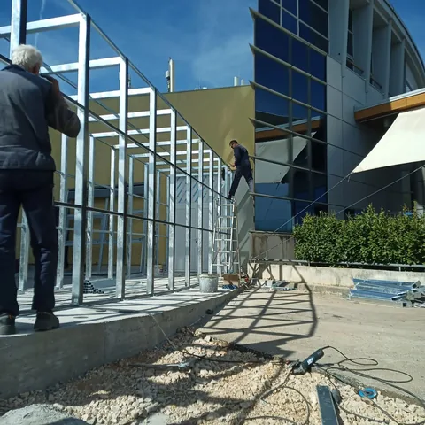 Montaža gustog rastera metalnih okvira uz vanjsko pročelje