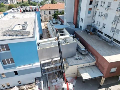 Zračna snimka bijelog čeličnog spojnog hodnika s djelomično postavljenom oblogom